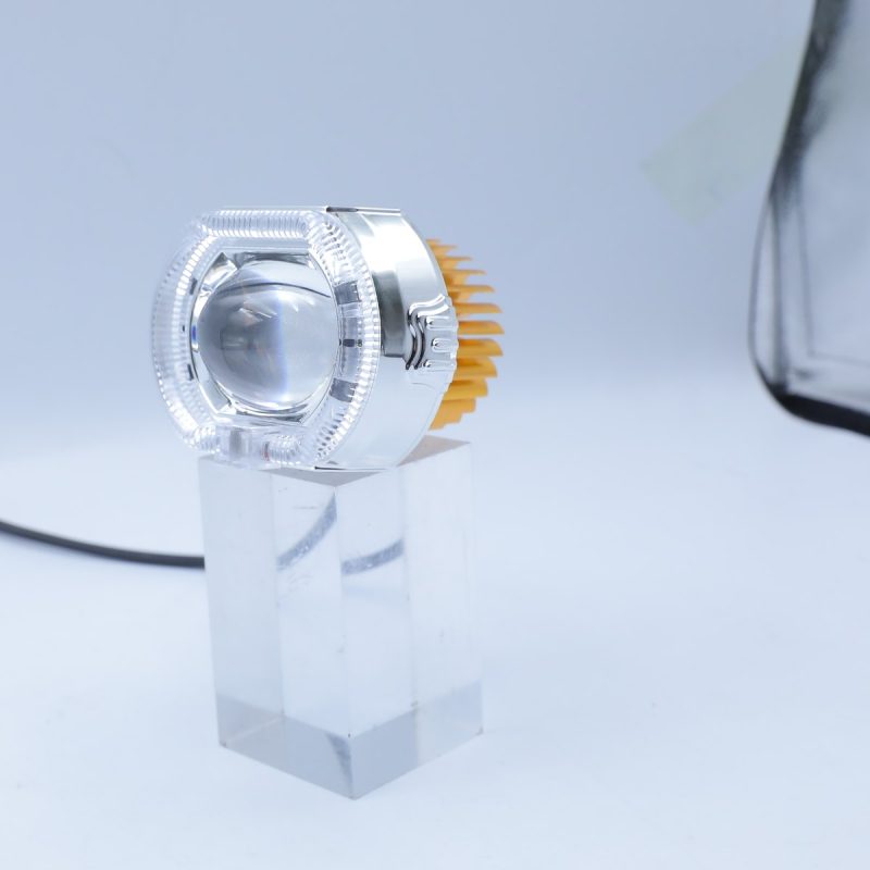 Small option angled view showing the clear lens shell, central projector, heat sink, and wire lead.